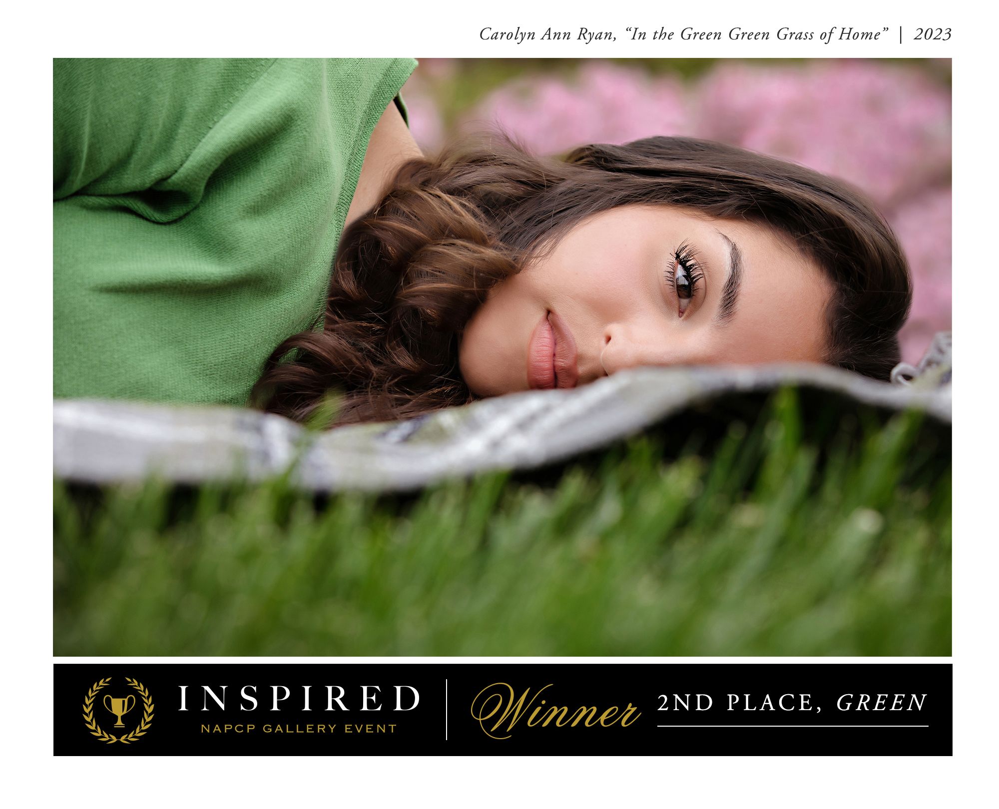 Portrait of a high school senior laying in the grass with pink flowers behind her. Above the portrait reads "Carolyn Ann Ryan, "In the Green Green Grass of Home" | 2023 and underneath it reads Inspired NAPCP Gallery Event, Winner 2nd Place, Green